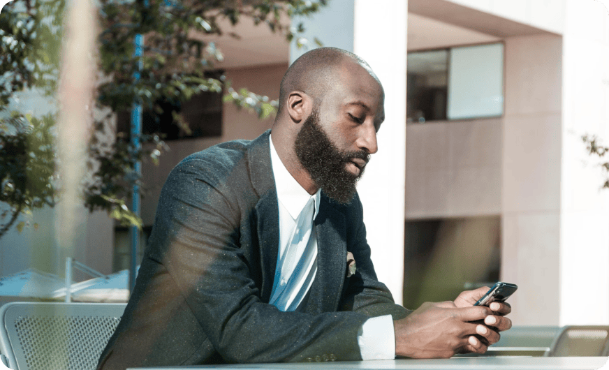 Picture of a man looking at his phone as he tracks his spending with Najar